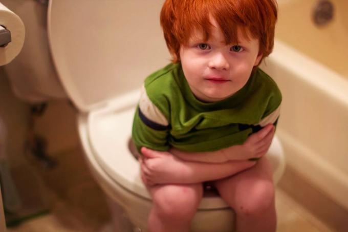 Malý chlapec sediaci na záchode