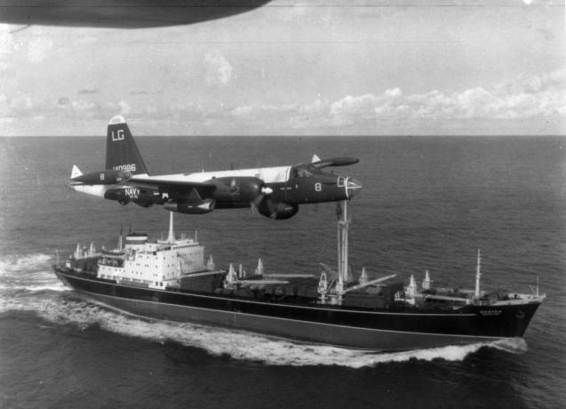 Počas tejto kubánskej raketovej krízy na tejto fotografii z roku 1962 poletuje americké hliadkové lietadlo P2V Neptún nad sovietskym nákladným autom.