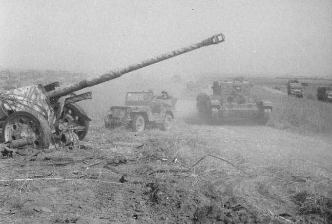 Britský tank postupoval okolo rozbitej nemeckej poľnej zbrane.
