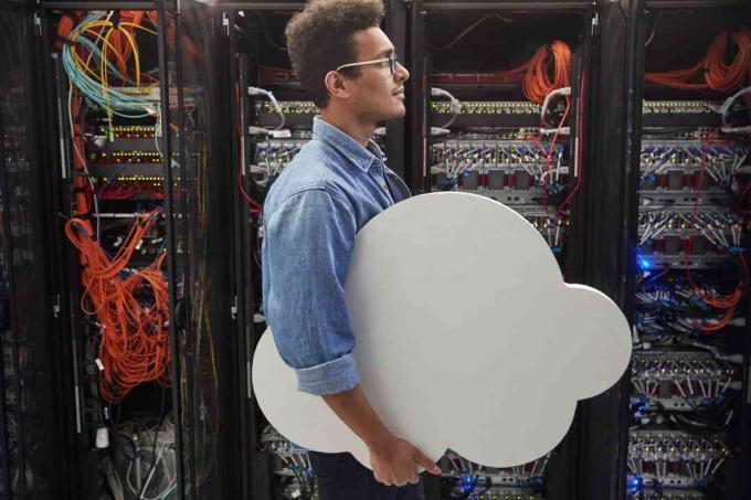 Muž IT technik prenášajúci cloud v serverovej miestnosti, cloud computing