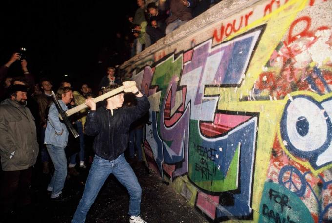 Muž útočí na berlínsky múr krumpáčom v noci 9. novembra 1989