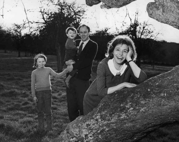 Čiernobiela fotografia Roalda Dahla, ktorý držal svoje deti; jeho manželka Patricia Neal sa opiera o strom