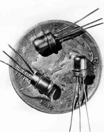 Obrázok z roku 1956 troch miniatúrnych tranzistorov M-1 videných na tvári desetníka