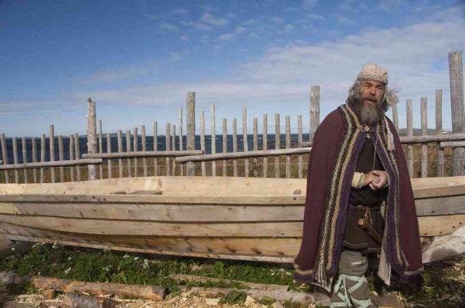 Vikingský herec v typickom oblečení pred replikou dlhých lodí, L'Anse Aux Meadows, Newfoundland