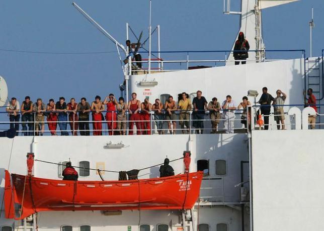 Somálski piráti, ktorí držia obchodné plavidlo MV Faina, stoja 19. októbra 2008 na palube lode s členmi posádky.