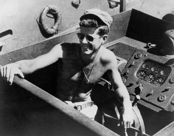 John F. Kennedy, tričko bez košele a slnečné okuliare, zatiaľ čo na čele PT-109.