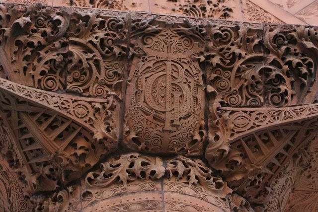 hnedá vyrezávaná terra cotta s detailami, ozdobenými kučerami a monogramom GB