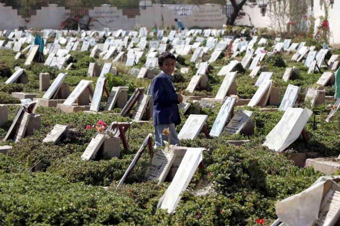 Dieťa chodí medzi hrobmi ľudí, ktorí boli zabití počas prebiehajúcej vojny, na cintoríne v Saná, Jemen.