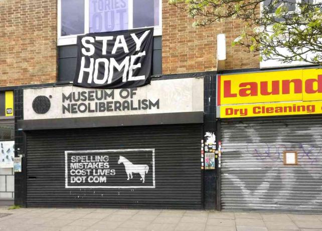 Veľké znamenie STAY HOME nad uzavretým Múzeum neoliberalizmu v Lewsiham, Londýn, Anglicko.